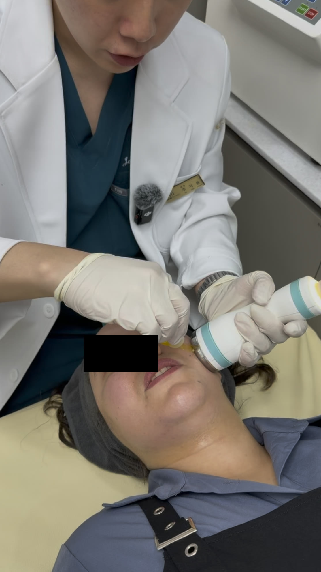 Coupling gel being applied before the Onda handpiece moves over the jawline at Tune Clinic; the patient's eyes are masked