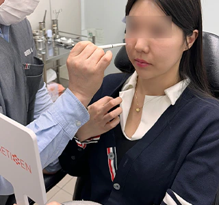 Physician and patient using a mirror during facial design planning