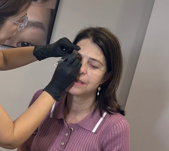 Brow artist working on a client's eyebrows at Tune